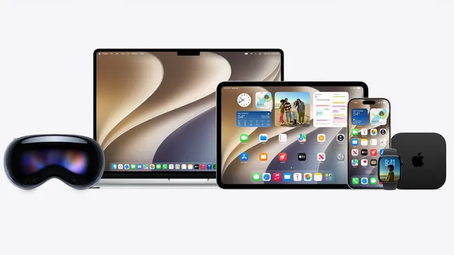 ภาพถ่ายผลิตภัณฑ์ที่แสดงกลุ่มอุปกรณ์ Apple หลายเครื่องวางเรียงกันบนพื้นหลังสีขาว จากซ้ายไปขวา: เฮดเซ็ตความเป็นจริงเสริม/เสมือน (VR/AR) (Apple Vision Pro), แล็ปท็อป MacBook, แท็บเล็ต iPad, สมาร์ทโฟน iPhone, สมาร์ทวอทช์ Apple Watch และกล่องรับสัญญาณ Apple TV