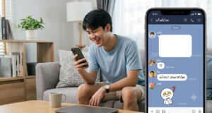 วิธีส่งข้อความว่างใน LINE แกล้งเพื่อนง่ายๆ ด้วยเทคนิคข้อความล่องหน ภาพ split-screen: ทางด้านซ้าย ผู้ชายชาวเอเชียอายุน้อยนั่งอยู่บนโซฟาสีเทาในห้องนั่งเล่นที่สว่างไสว กำลังยิ้มและหัวเราะขณะมองลงมาที่สมาร์ทโฟนในมือของเขา ทางด้านขวา มีส่วนแทรกหน้าจอสมาร์ทโฟนขนาดใหญ่